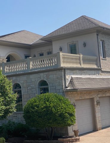 Luxury stone facade home with balustrade balcony